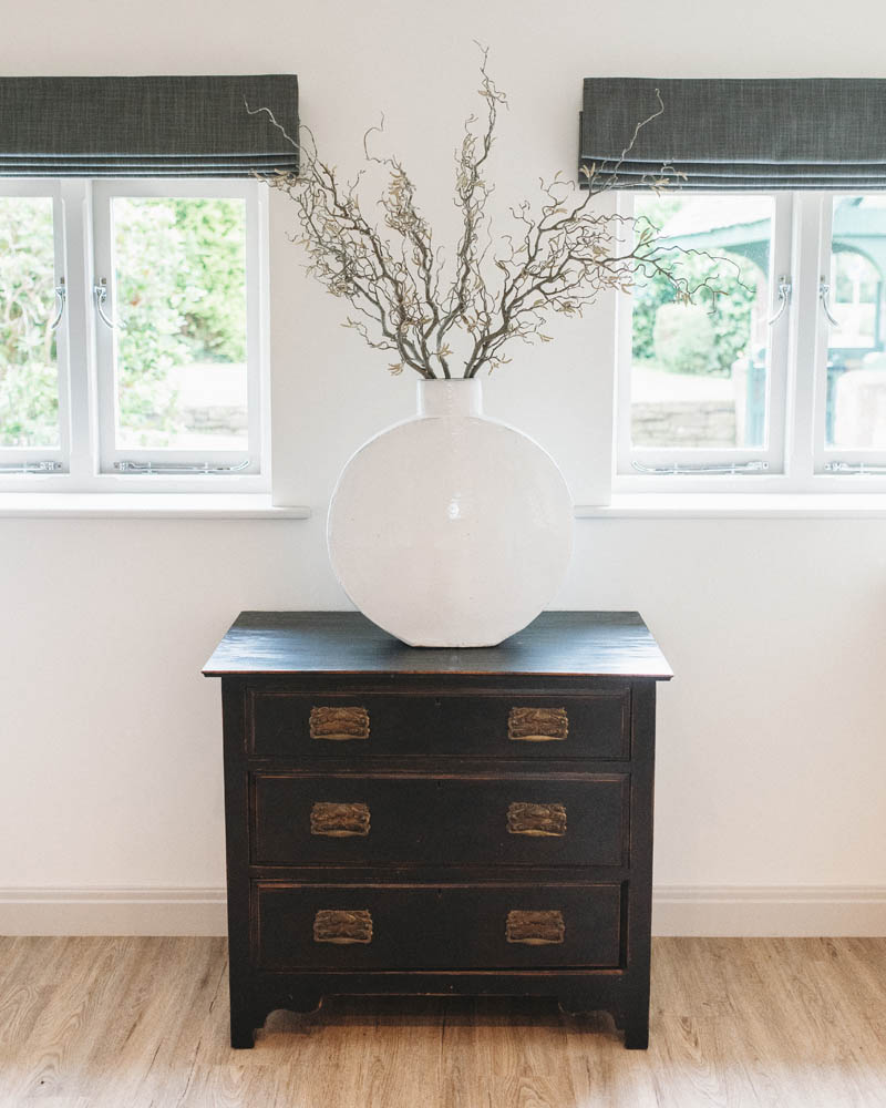black drawers with large white vase on top