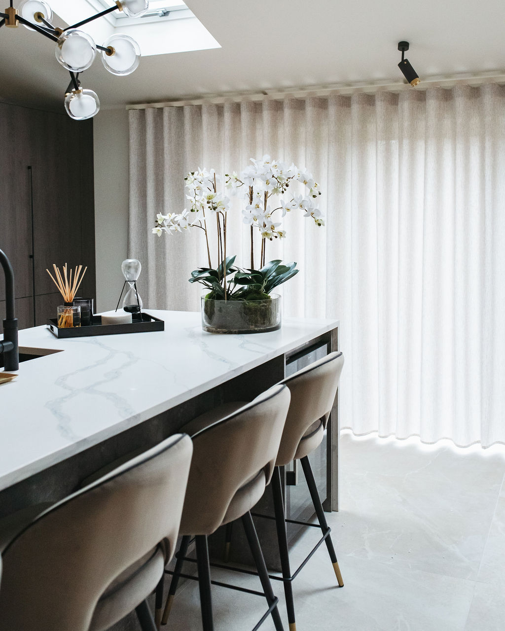 the interior design of a kitchen with marble breakfast bar