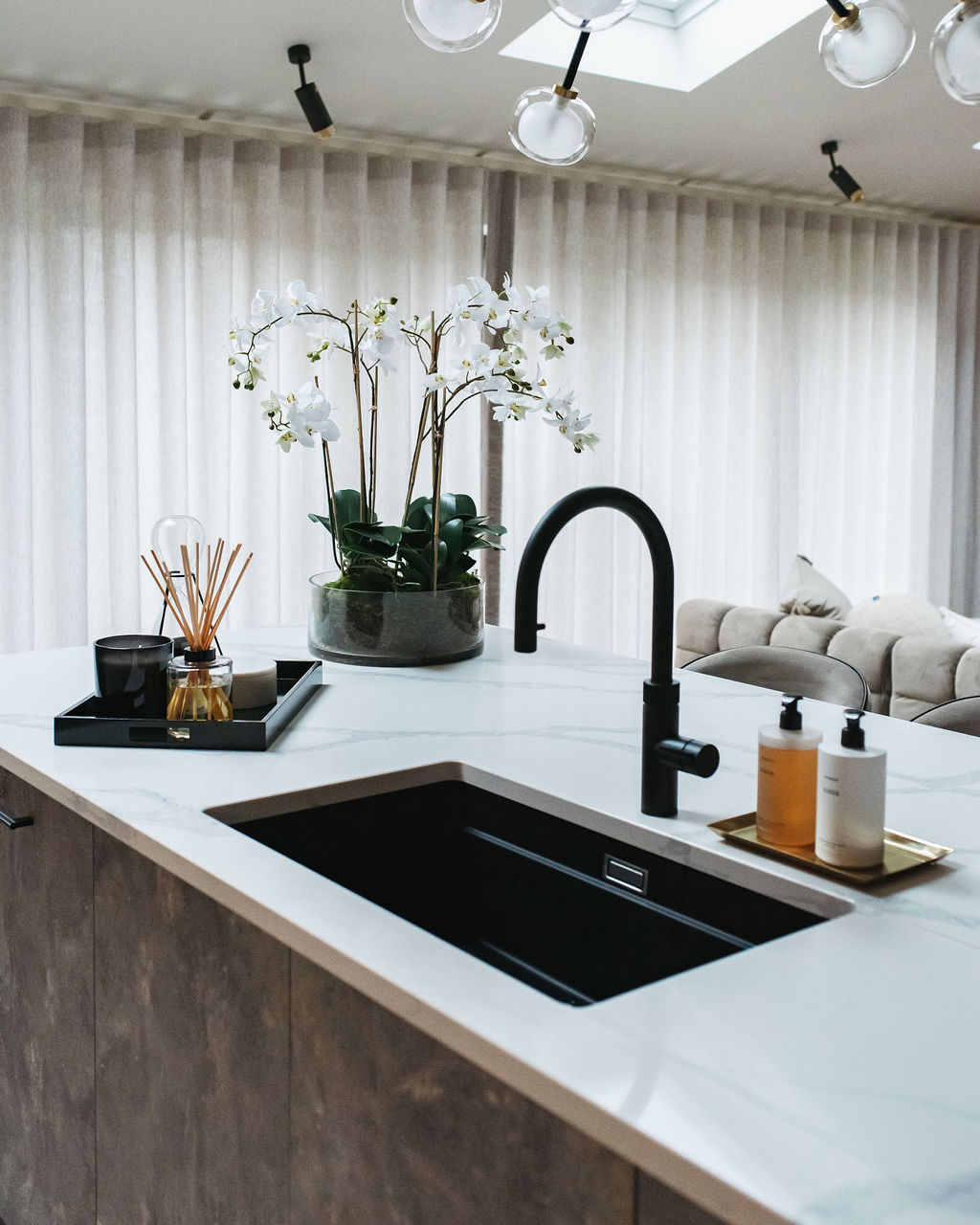 the interior design of a kitchen with black sink and taps