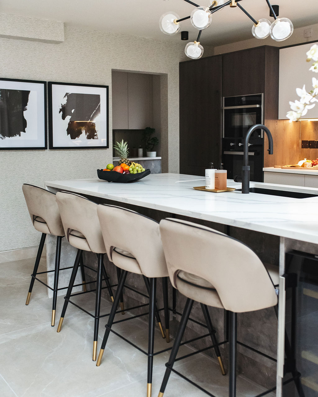 the interior design of a kitchen with cream stools and a marble floor