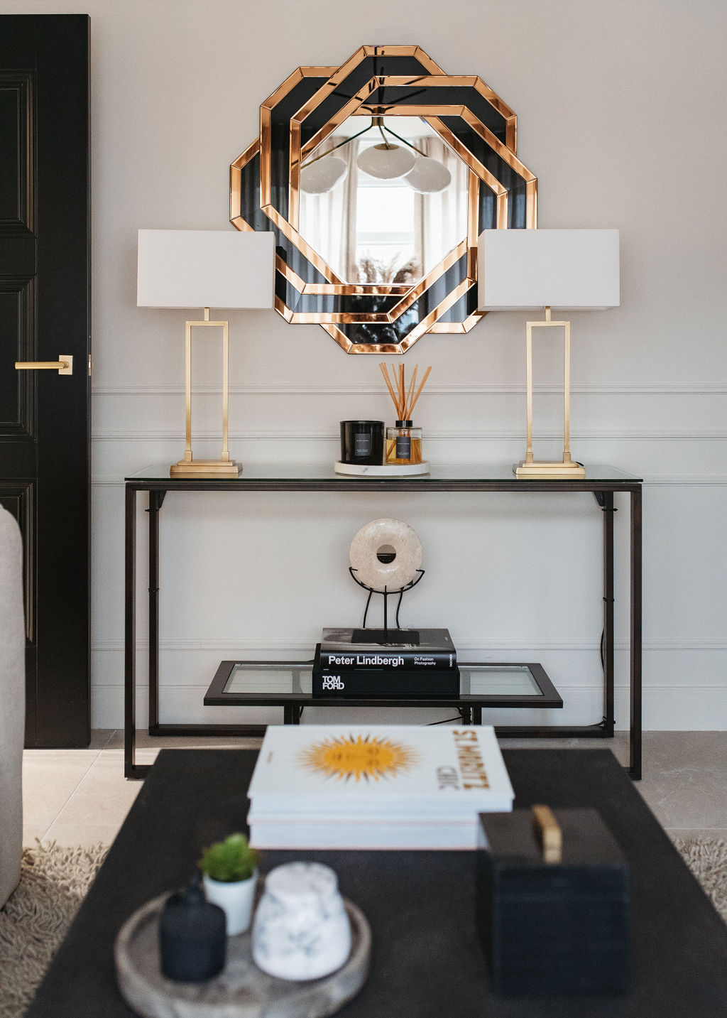 close up of the hale house interior featuring a black console table and black and gold mirror