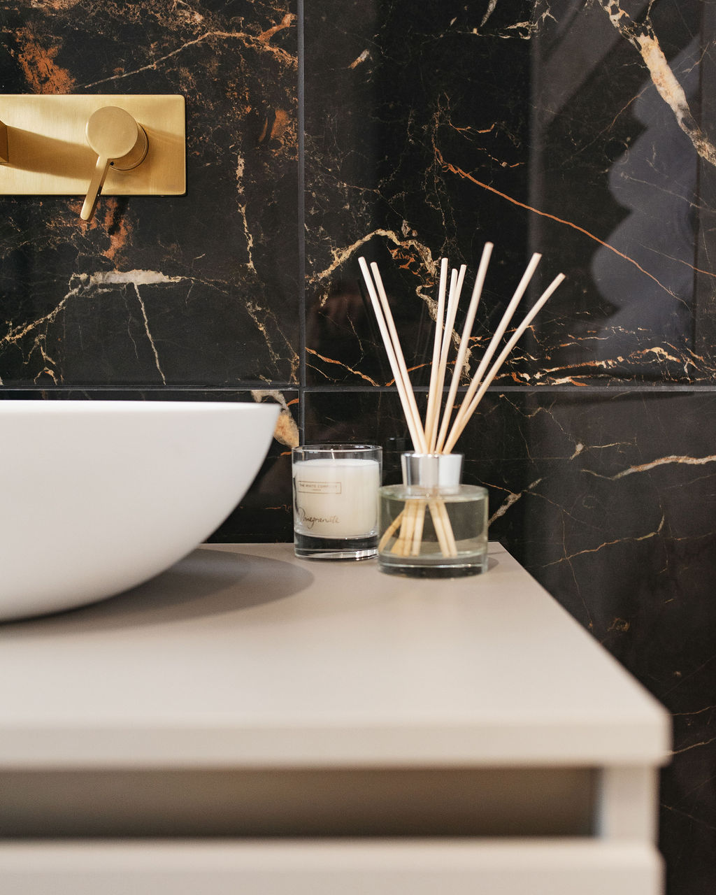 a sink vanity unit with black marble walls