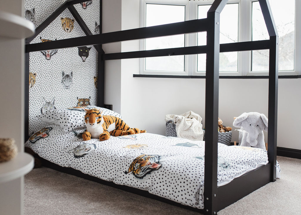 interior design in a childs bedroom with a black bed in the shape of a house and tiger wallpaper
