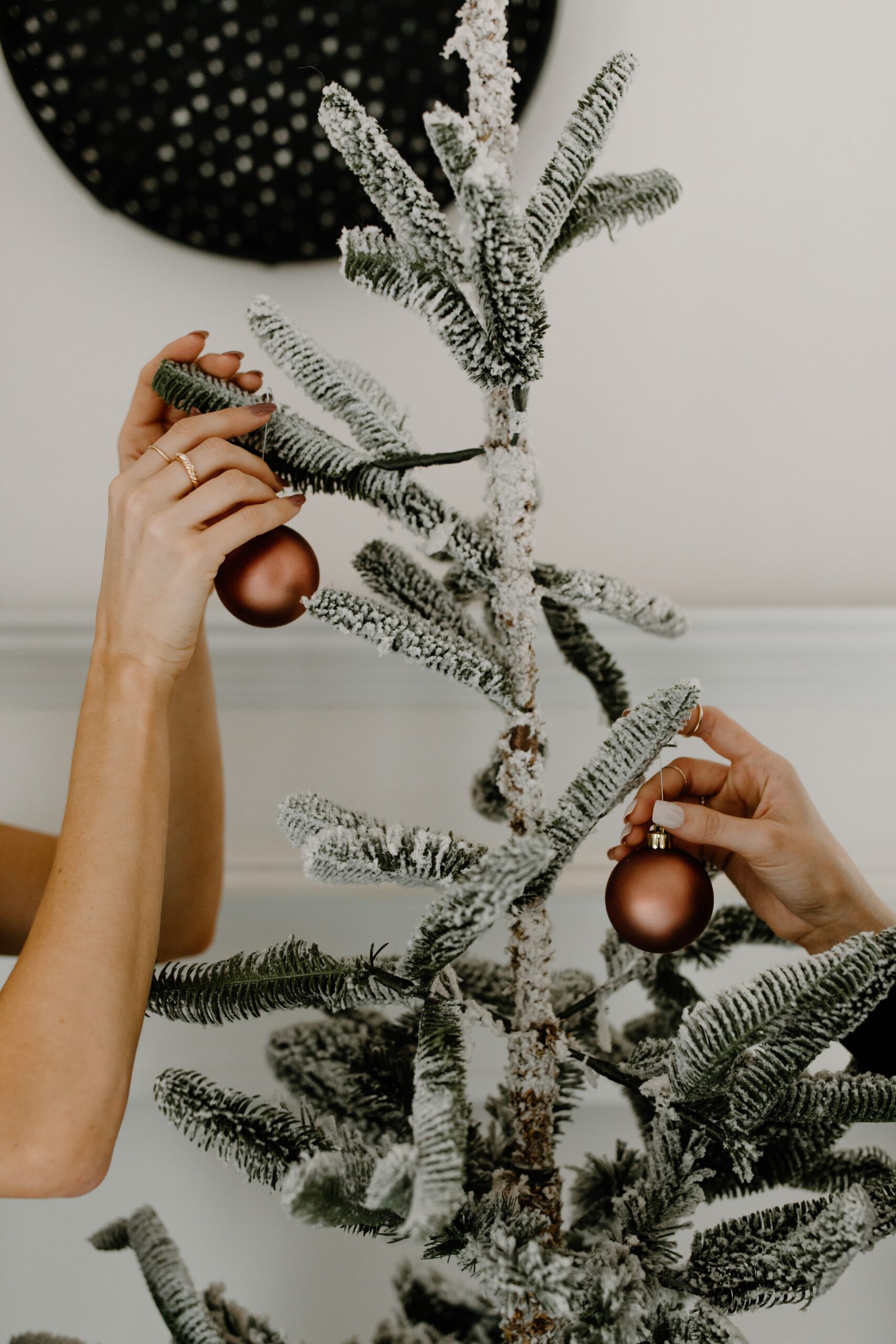 hands decorating Christmas tree